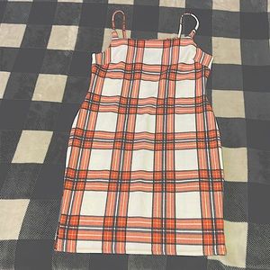 Im selling this plaid orange white and black dress its never been worn brand new